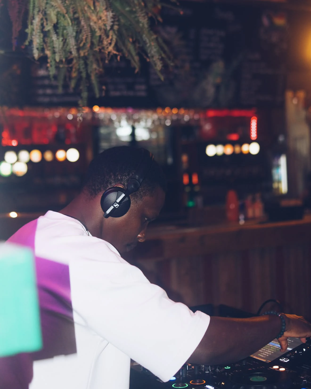DJ sett fra siden med hodetelefoner ved miksebordet